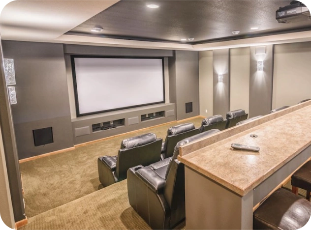 a room with a large screen and chairs